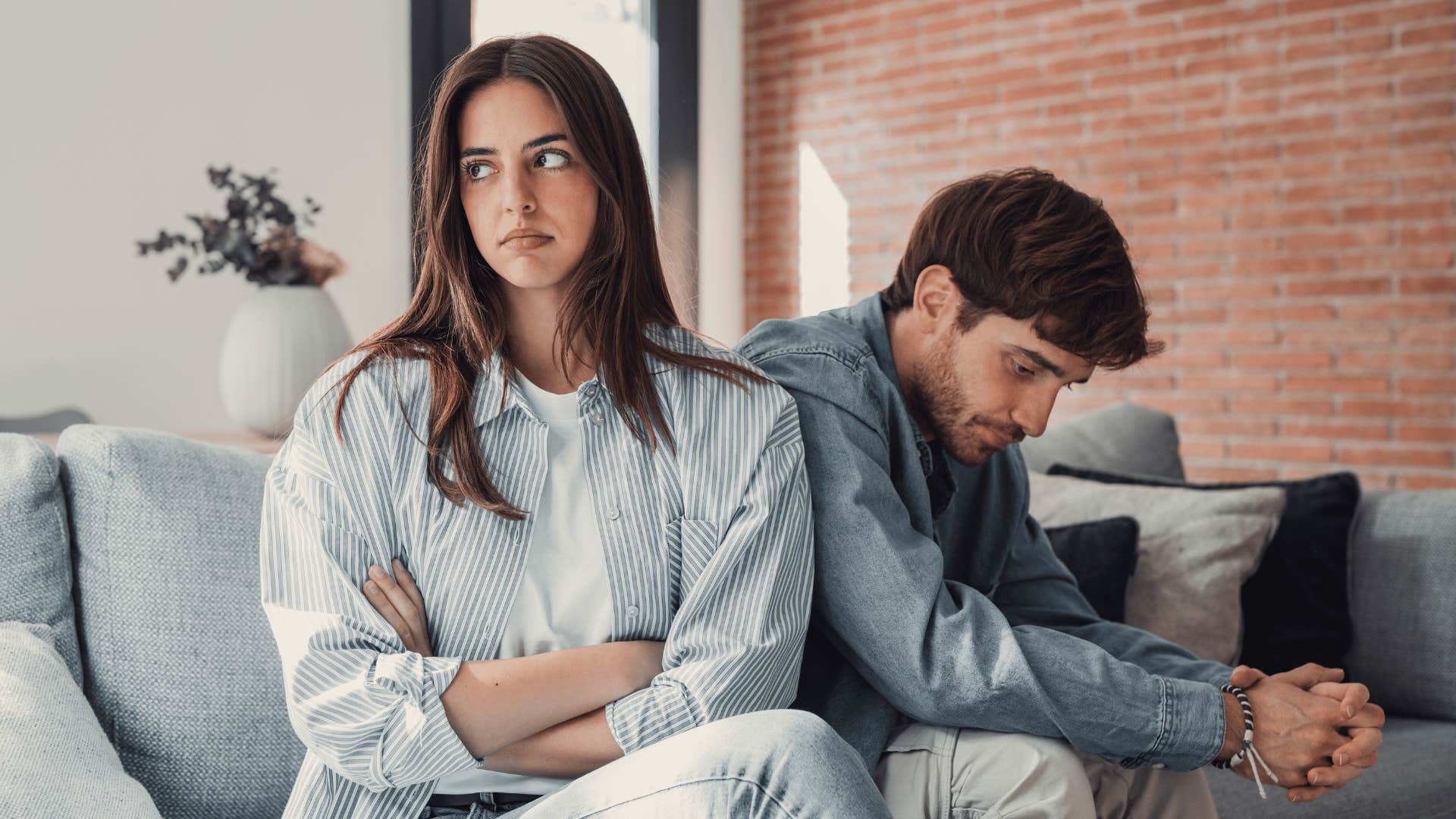 Couple on couch, both look away from each other