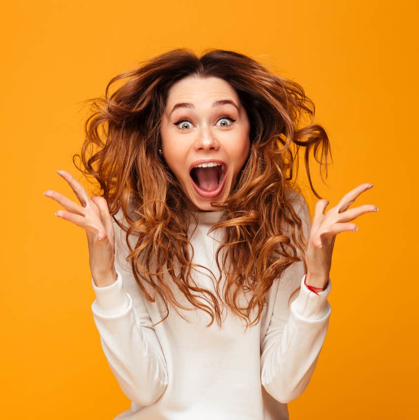 Excited woman express with hands and face, her hair is in motion