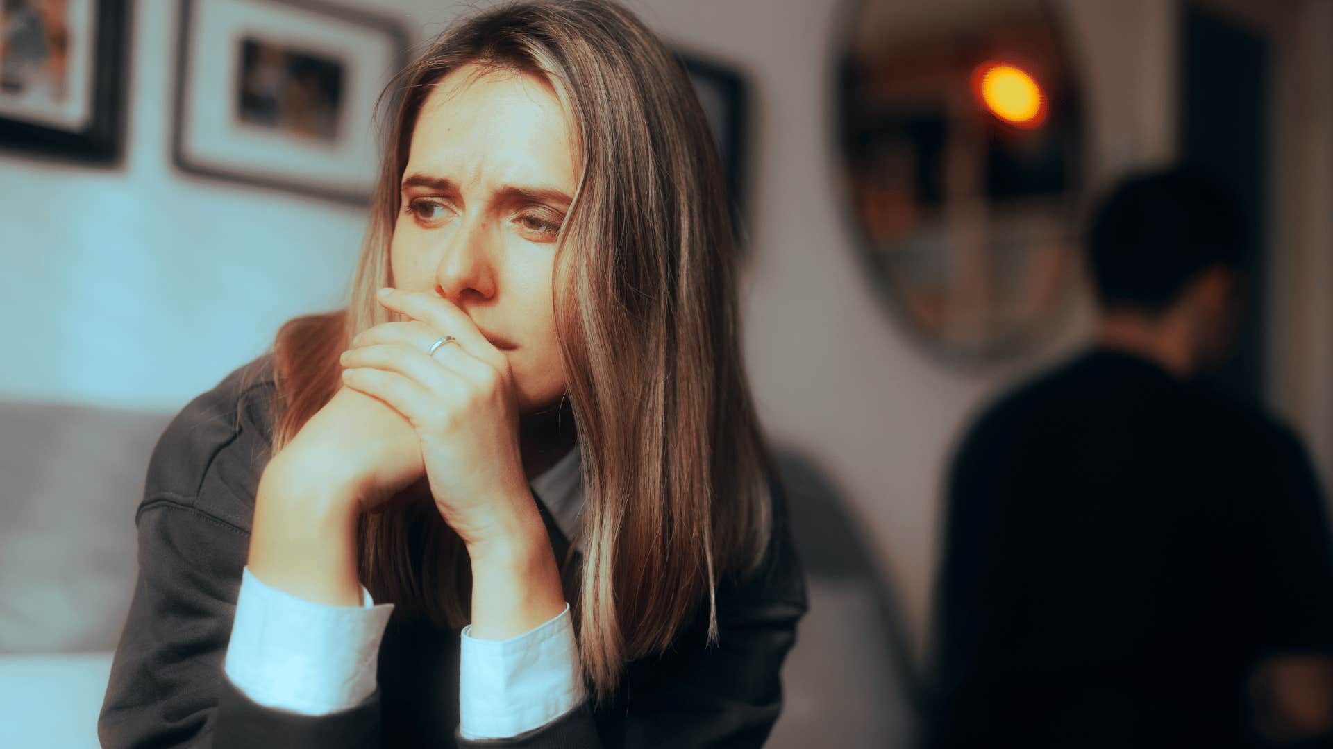 man walking away from woman while she sits down looking upset 