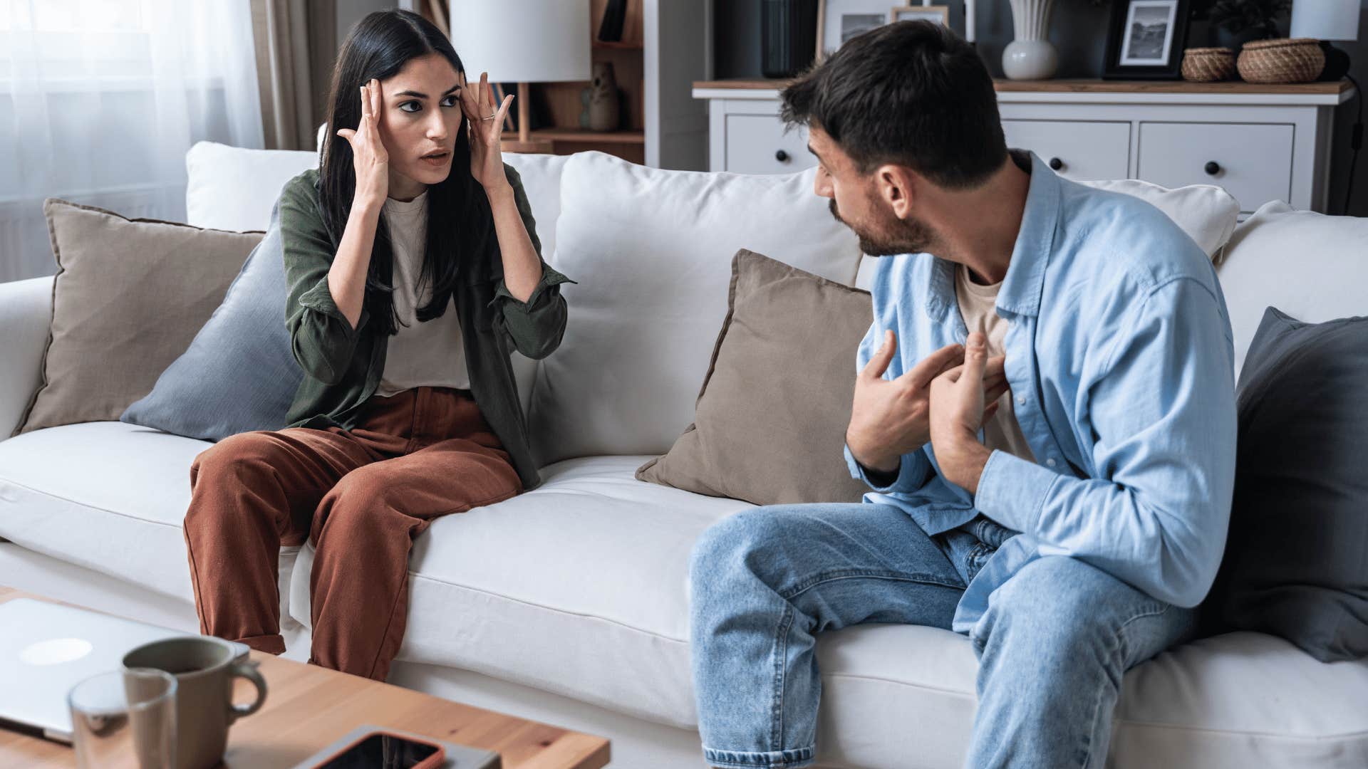 man and woman arguing on couch