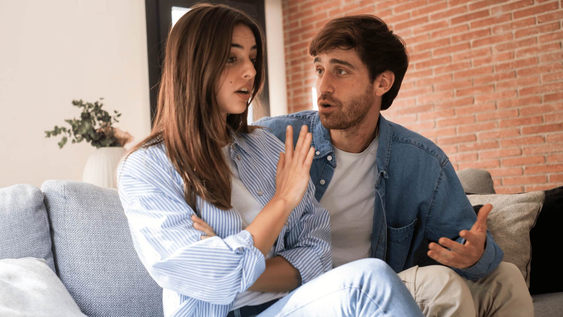 woman holding up hand to man