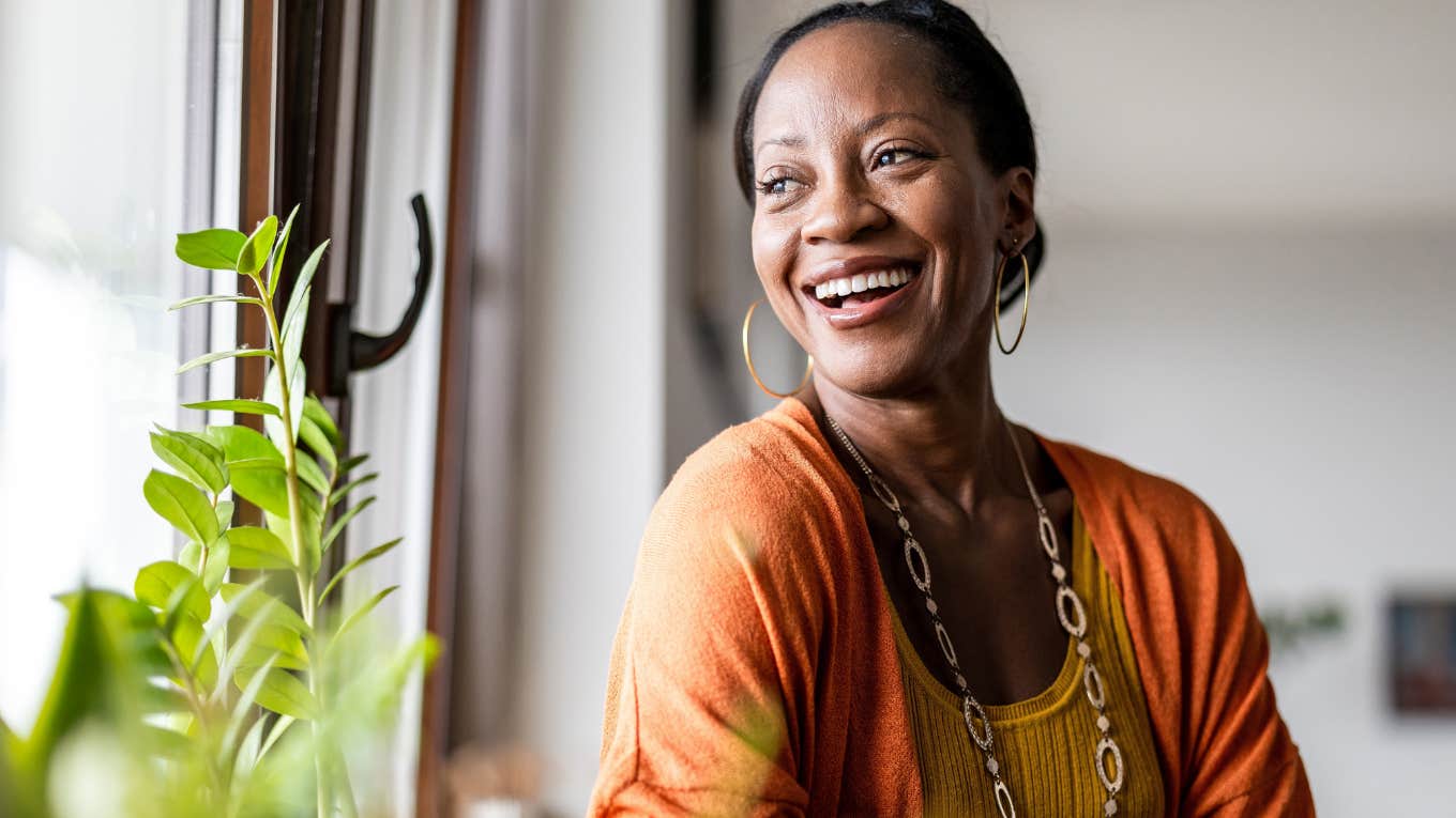 Type B woman smiling while looking out the window.