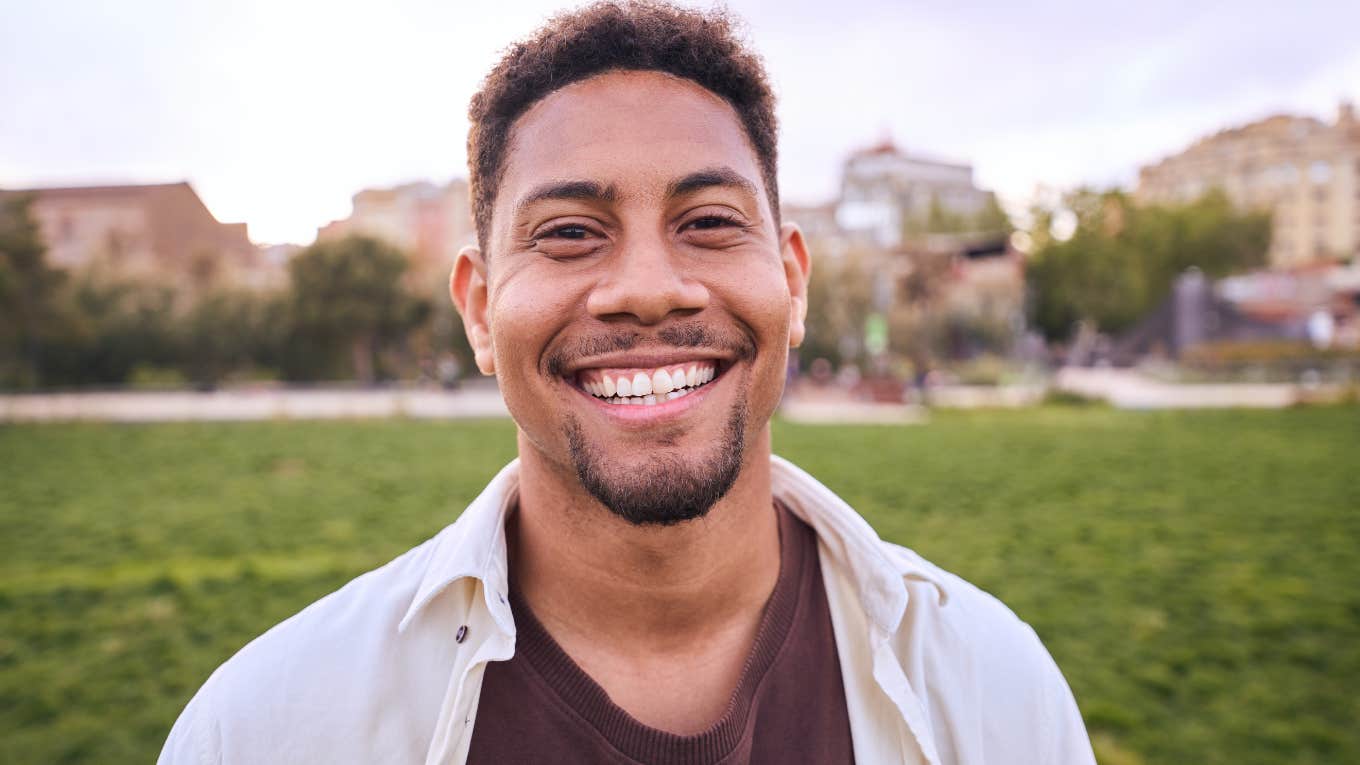 Man smiling while walking outside.