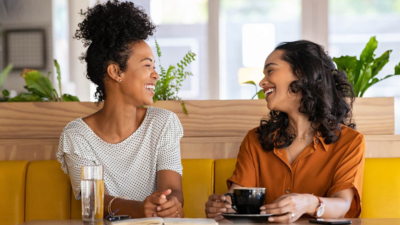 Two women smiling and talking to each other.