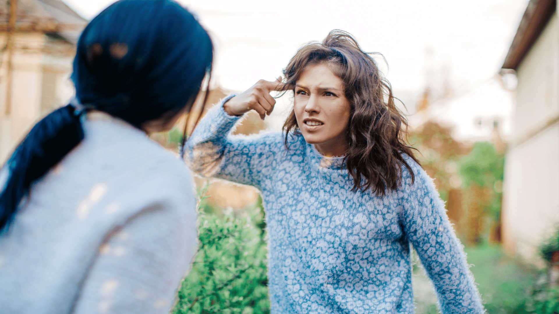 Couple argues, one points to side of her head aggressively