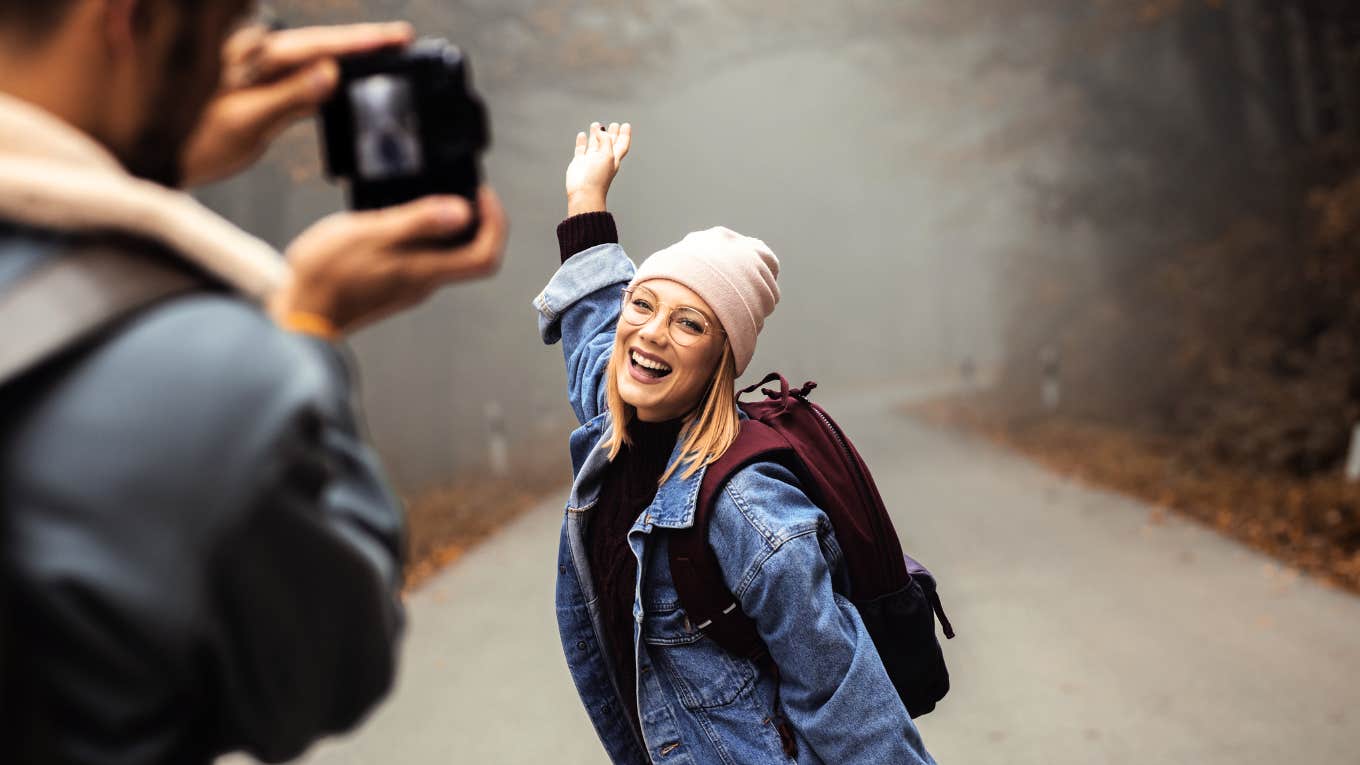 Man taking cute photos of his girlfriend while on a hike.