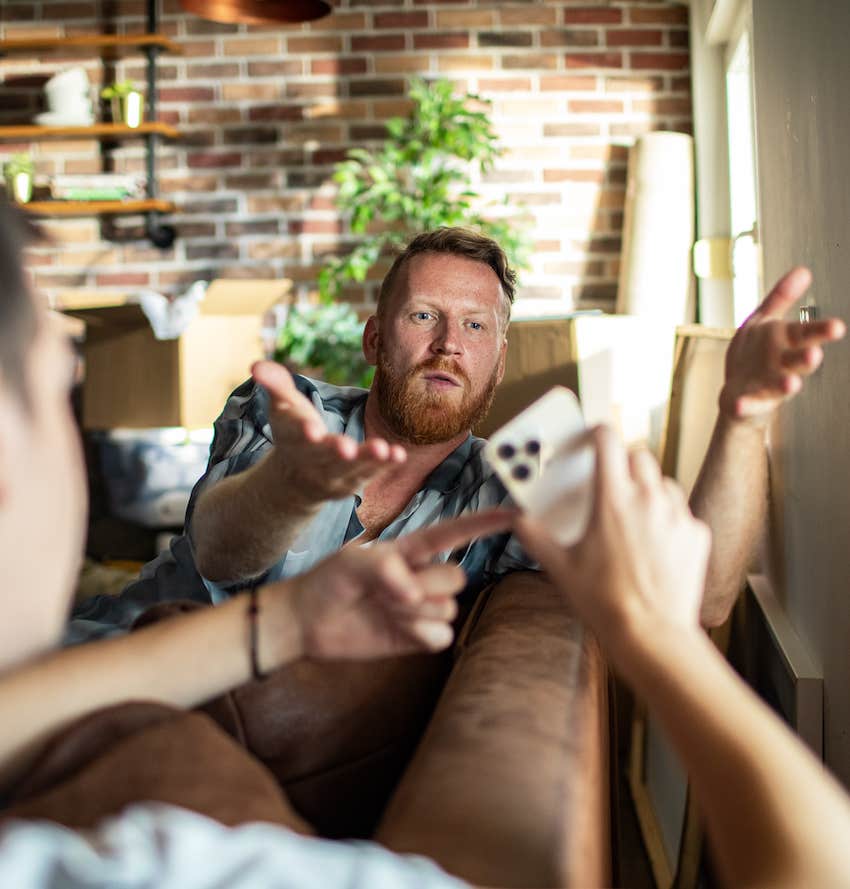 He gestures to explain as partner points at mobile device