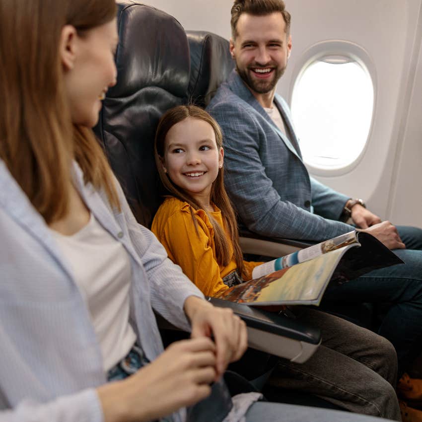 Little girl sitting in the middle seat on a plane