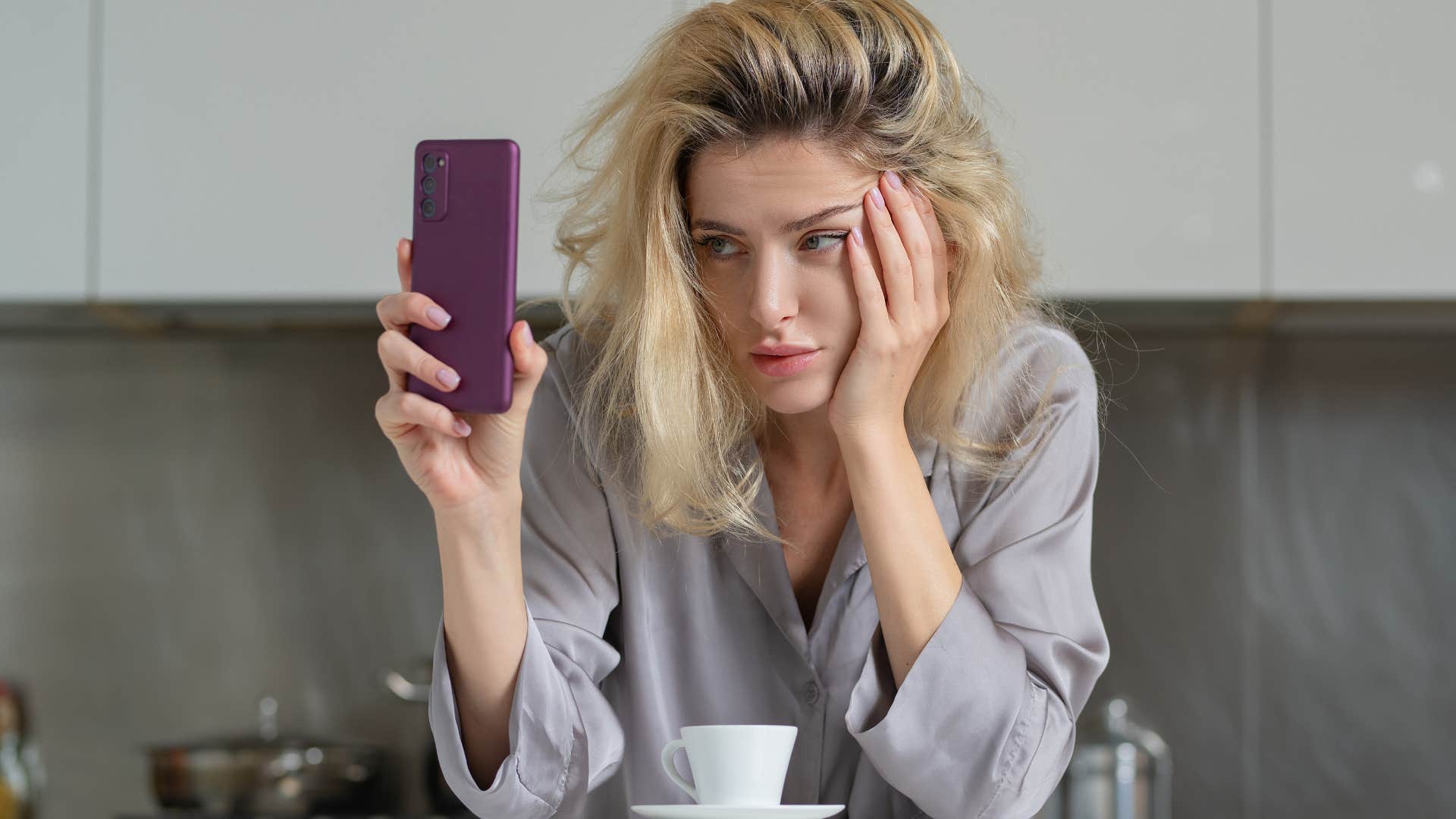 Woman looking tired and staring at her phone