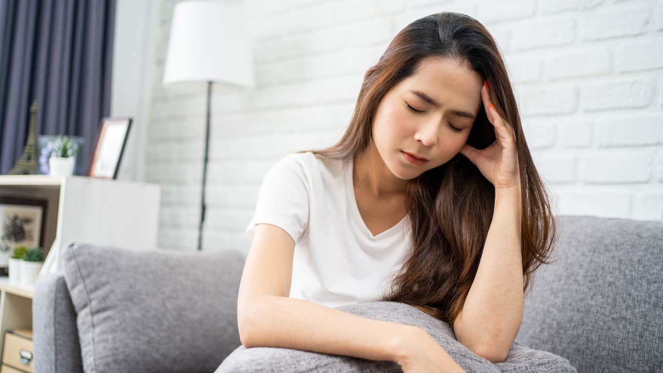 woman sitting on the couch with headache