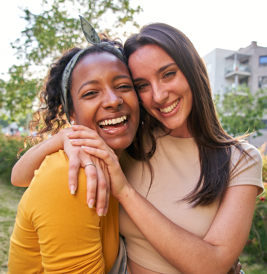 Couple hugs and smiles in a park