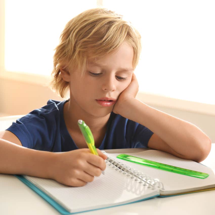 confused little boy doing homework