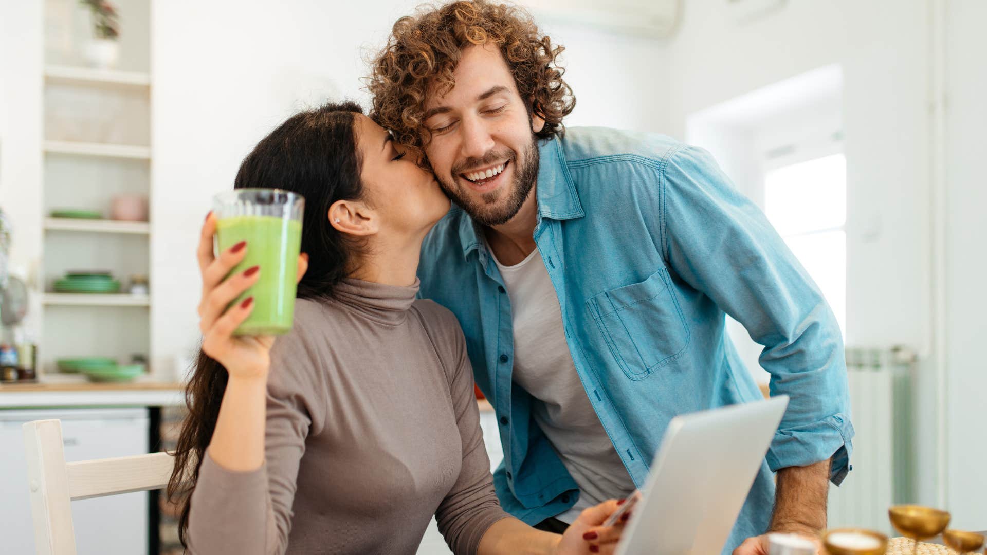 Couple hugging and smiling together in the kitchen. 