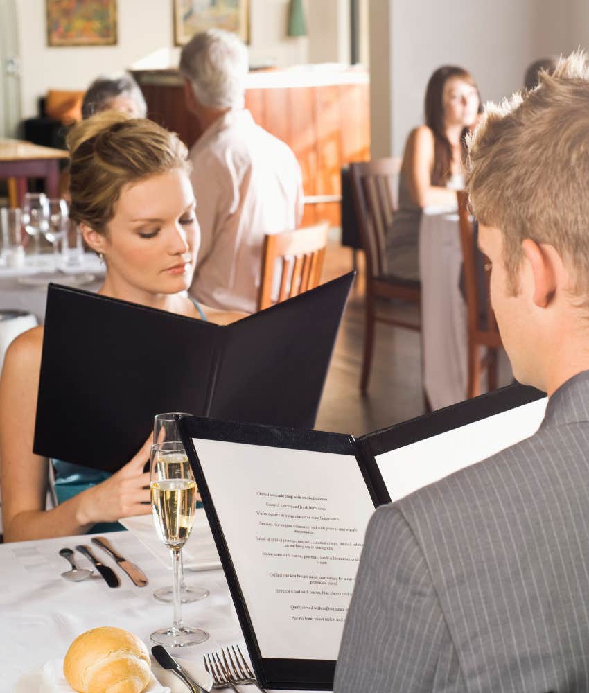 couple reading menus in restaurant