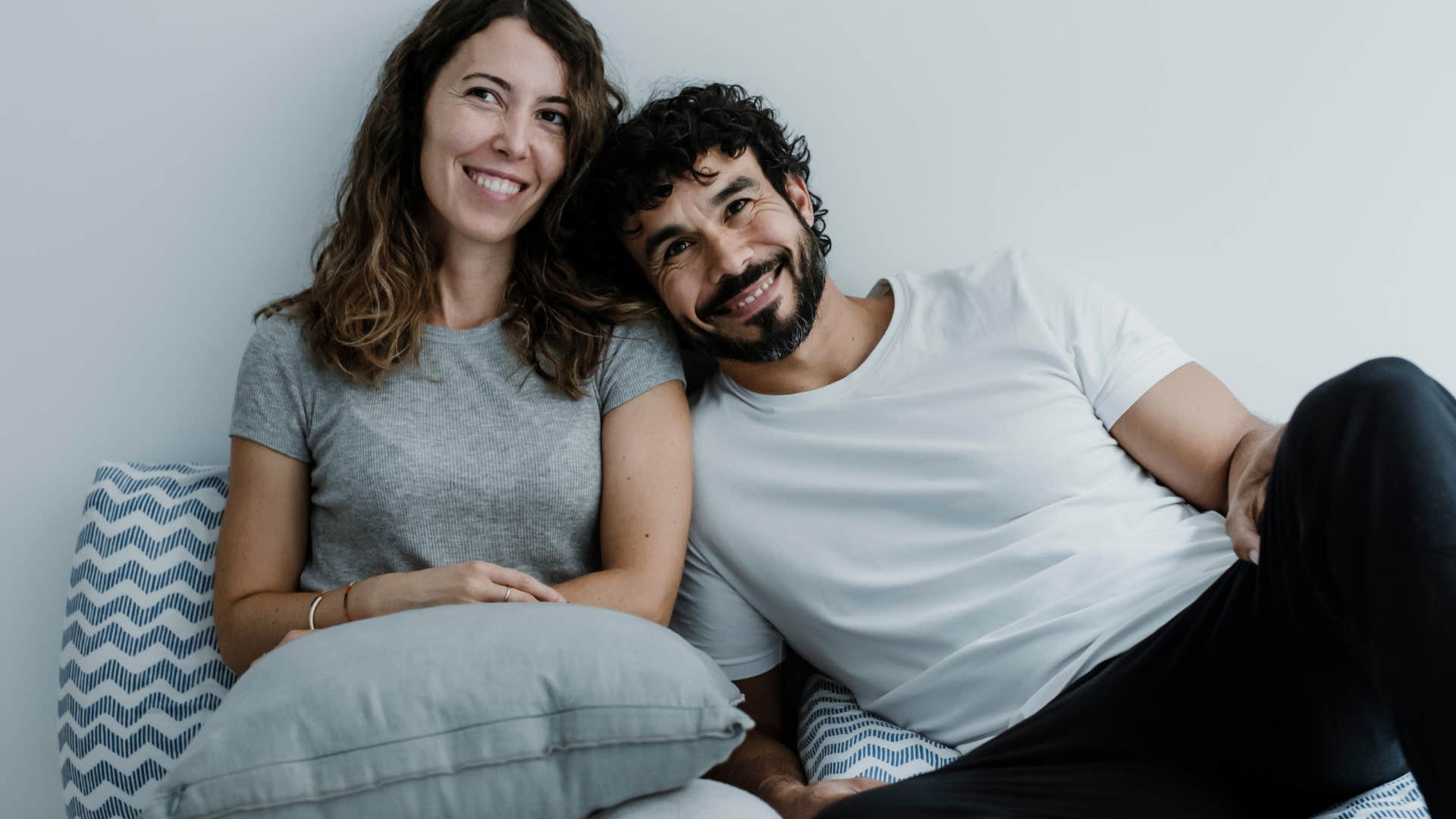 Woman looking happy with her partner on the couch.