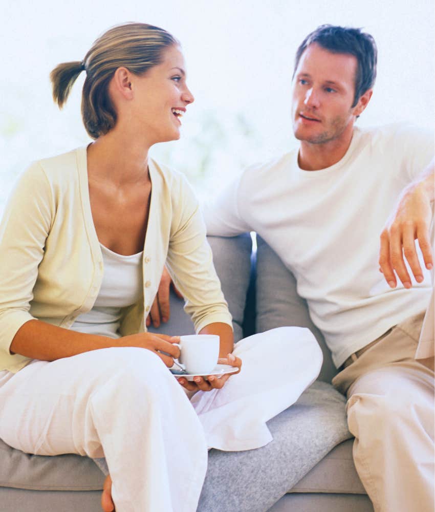 couple talking on couch while drinking coffee