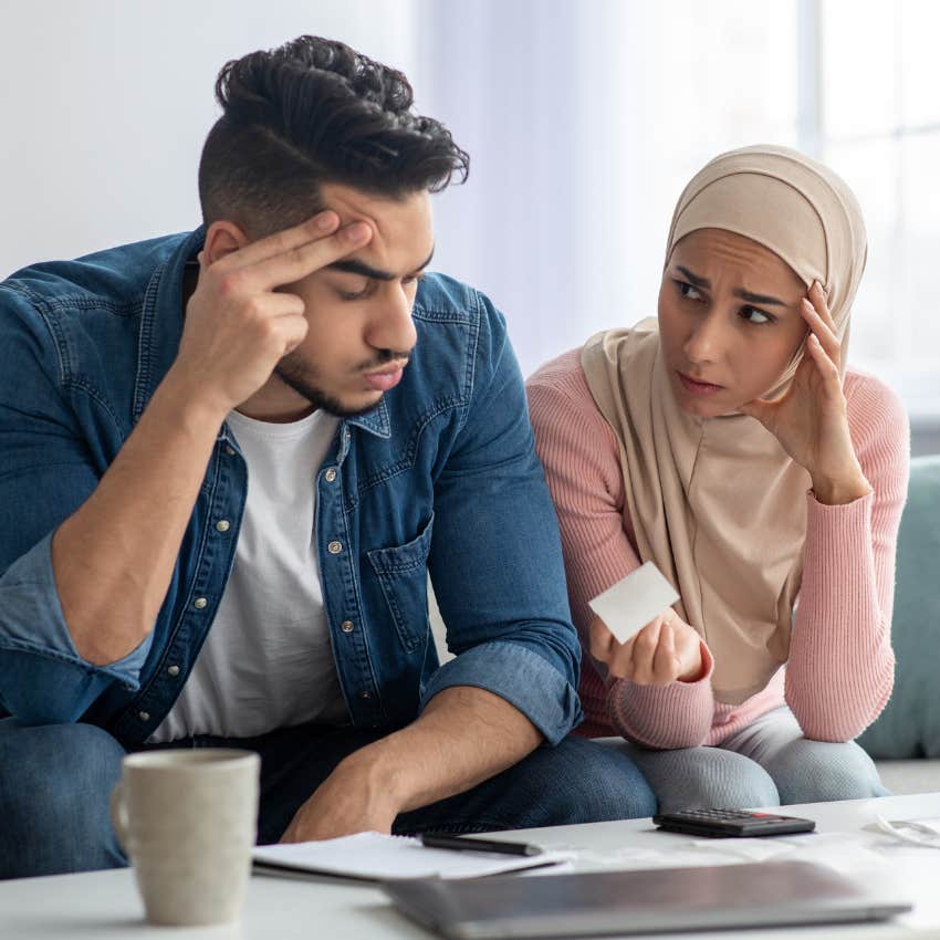 Girlfriend looking upset next to her partner over paying rent. 