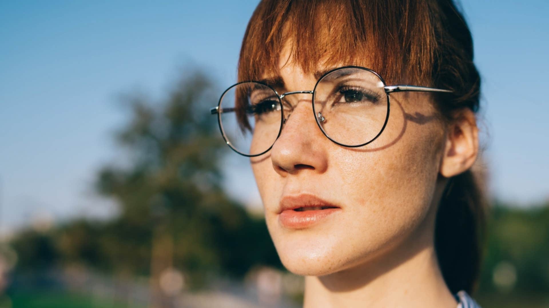 Woman looking solemnly deep in thought.