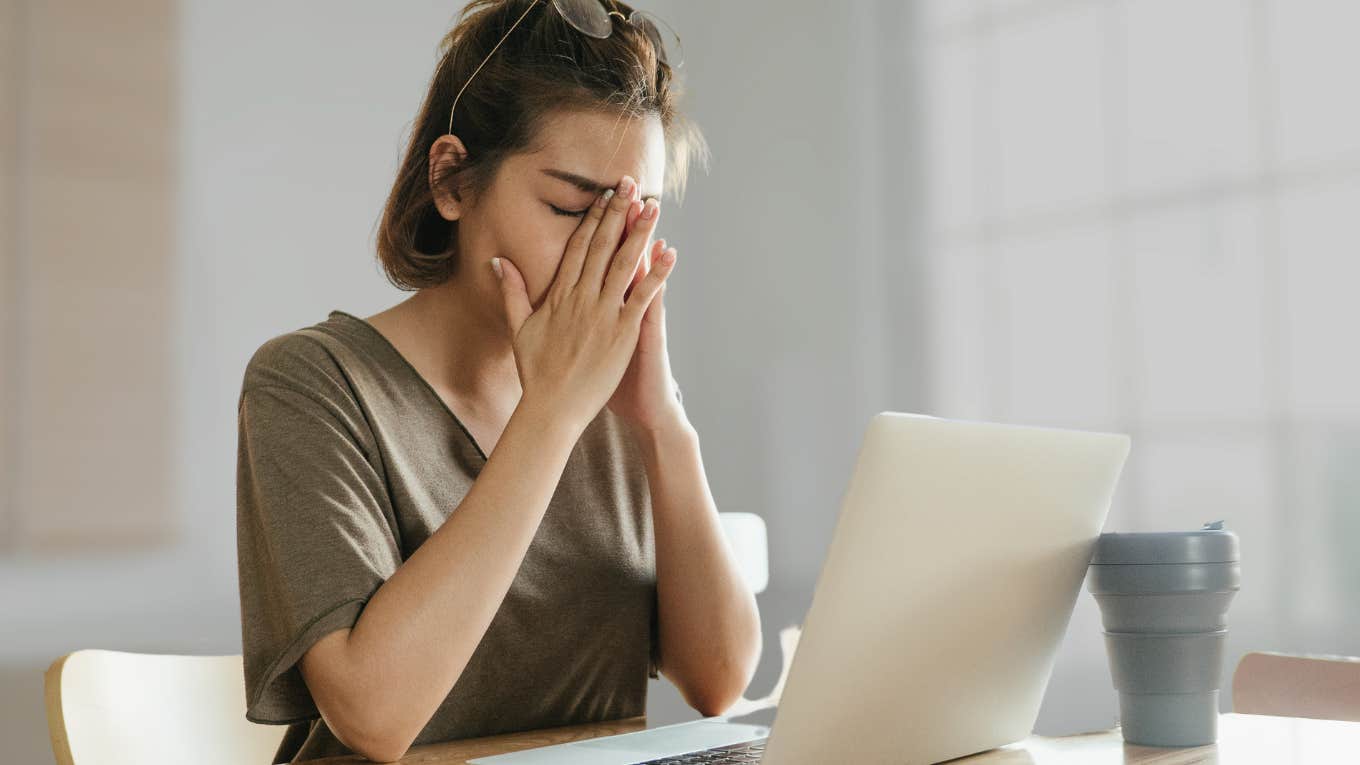 Woman looking frustrated at her laptop over conversation on Depop.