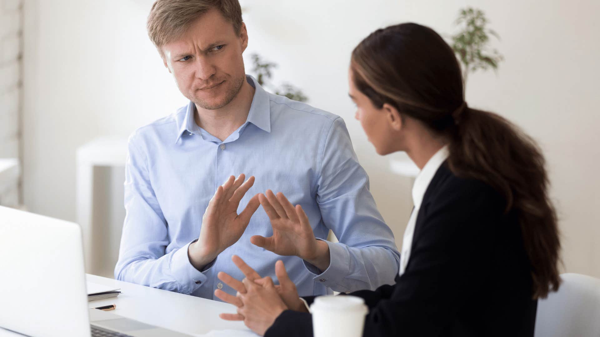 He rejects her idea by putting up hands and expressing disinterest