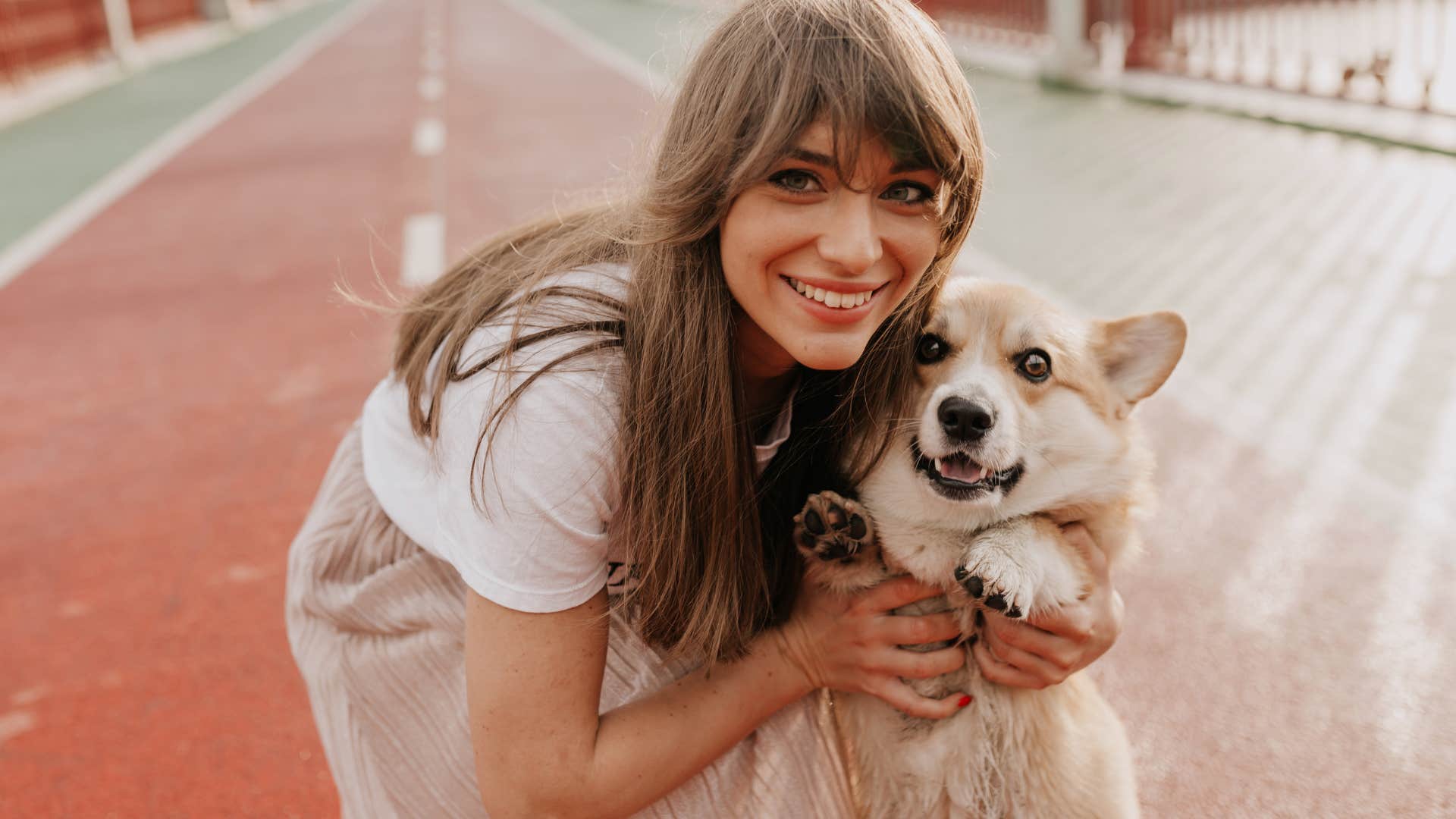 Woman smiling while hugging her dog