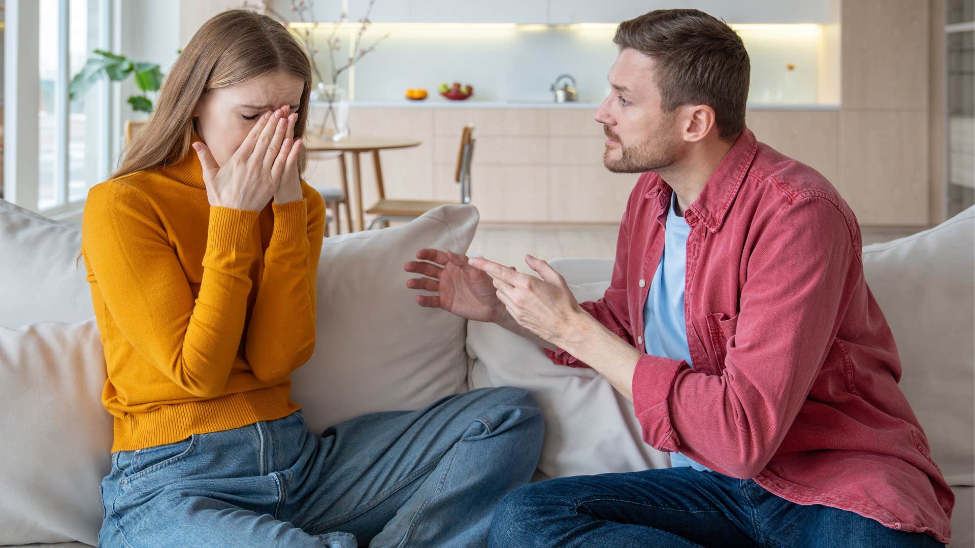 Man looking upset while his girlfriend cries.