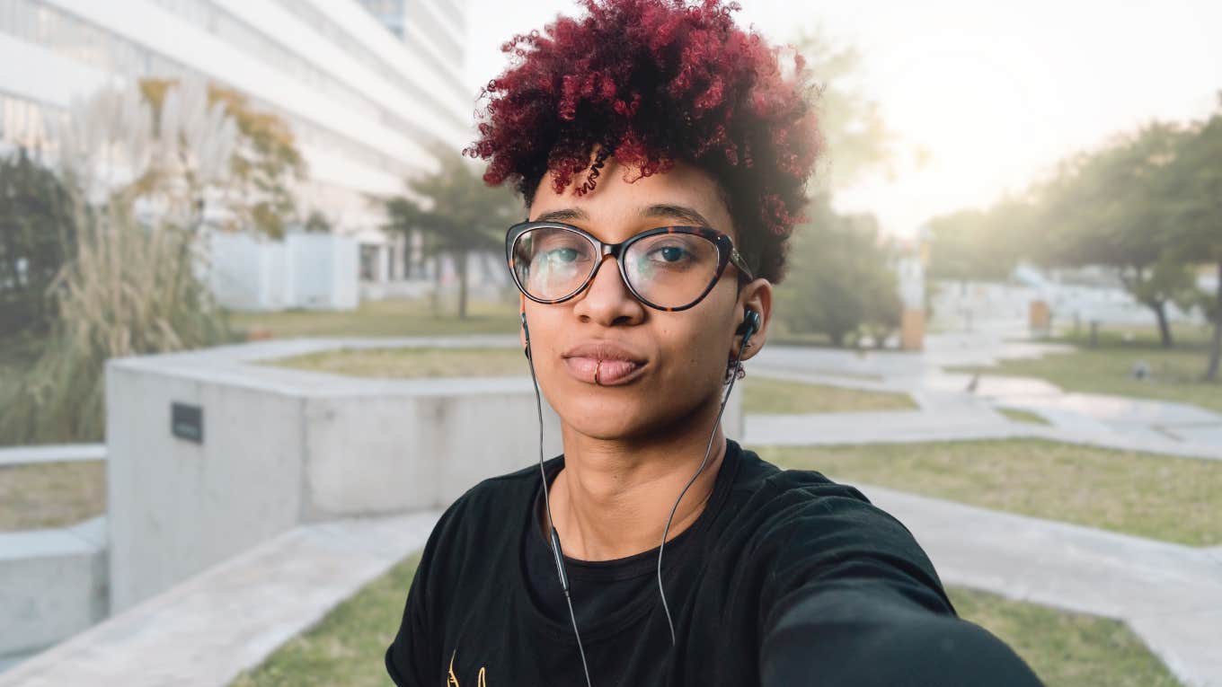 Person looking confident and smiling at the camera outside. 