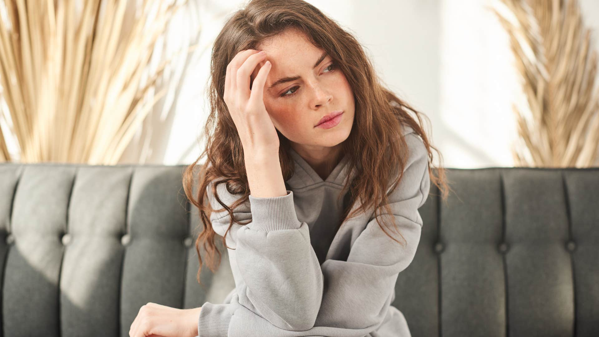 Woman looking embarrassed on her couch.