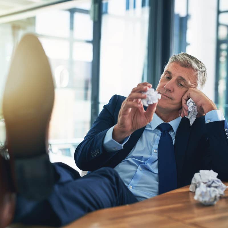 Bored businessman crumpling paper in office