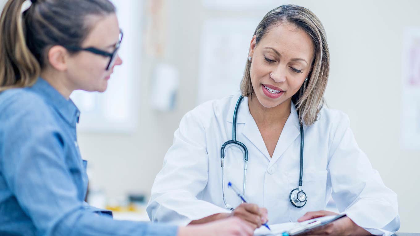 Doctor writing a note for a female patient