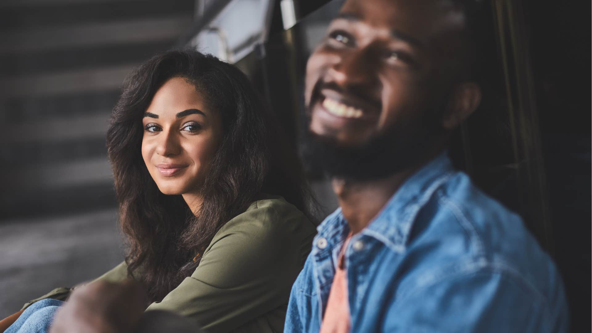 Couple smiling while staring at another person