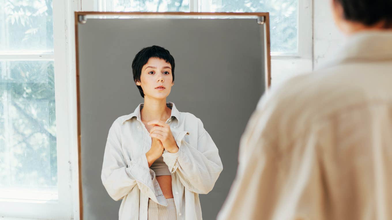 Woman looking at herself in mirror.