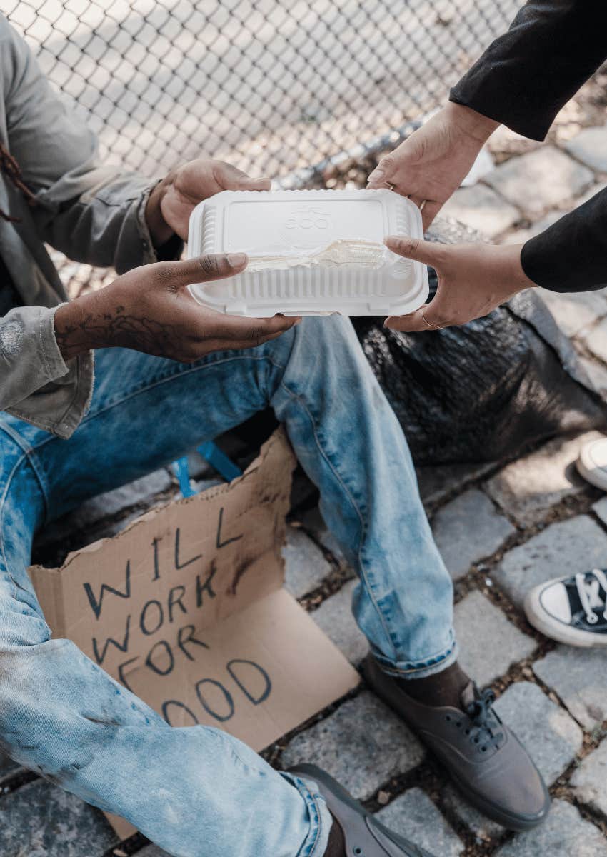 food being handed to a homeless man