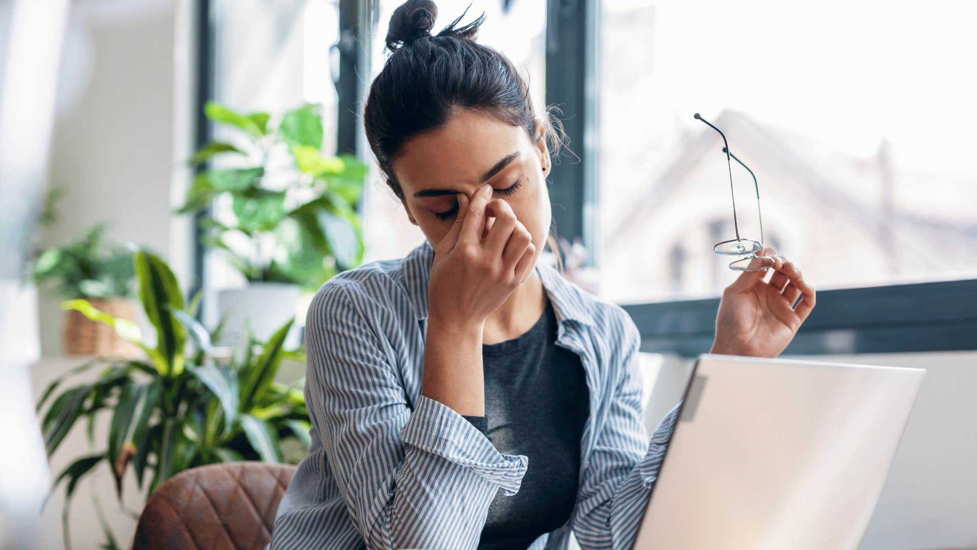 Gen Z woman looking stressed because of her Gen X and millennial coworkers