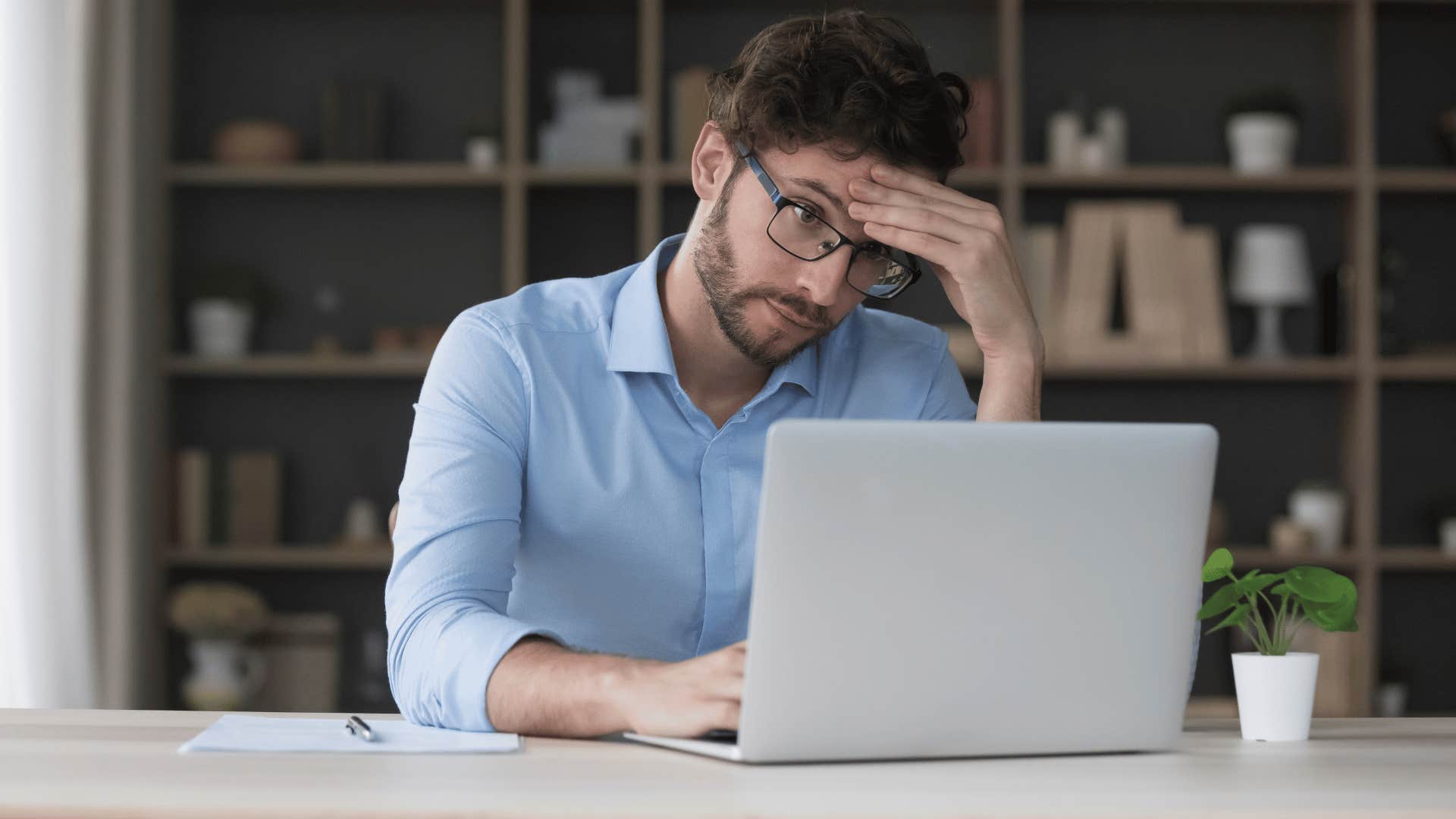 man looking at laptop frustrated 