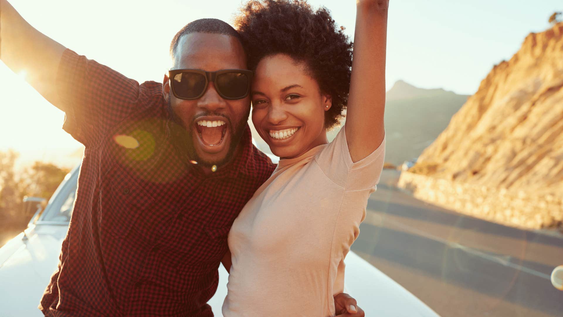 Excited couple raise arms in the air