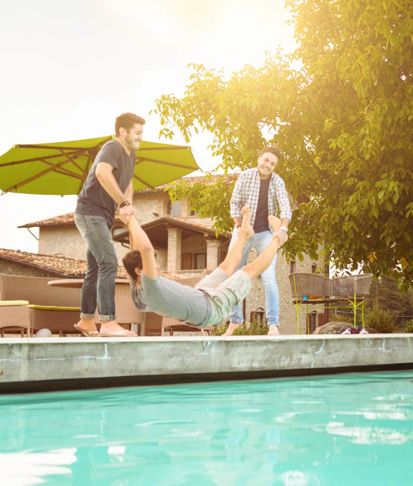 friends throwing groom into pool at bachelor party