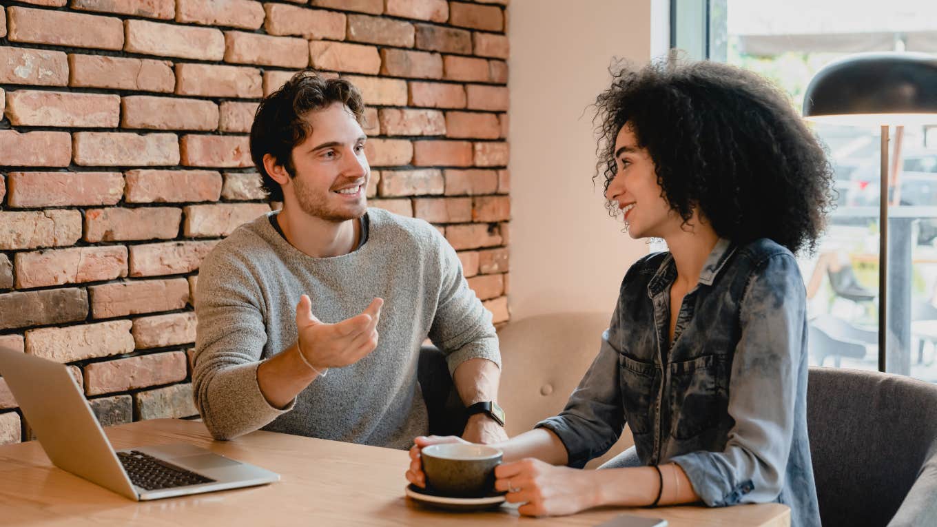 man and a woman sitting together in a cafe talking