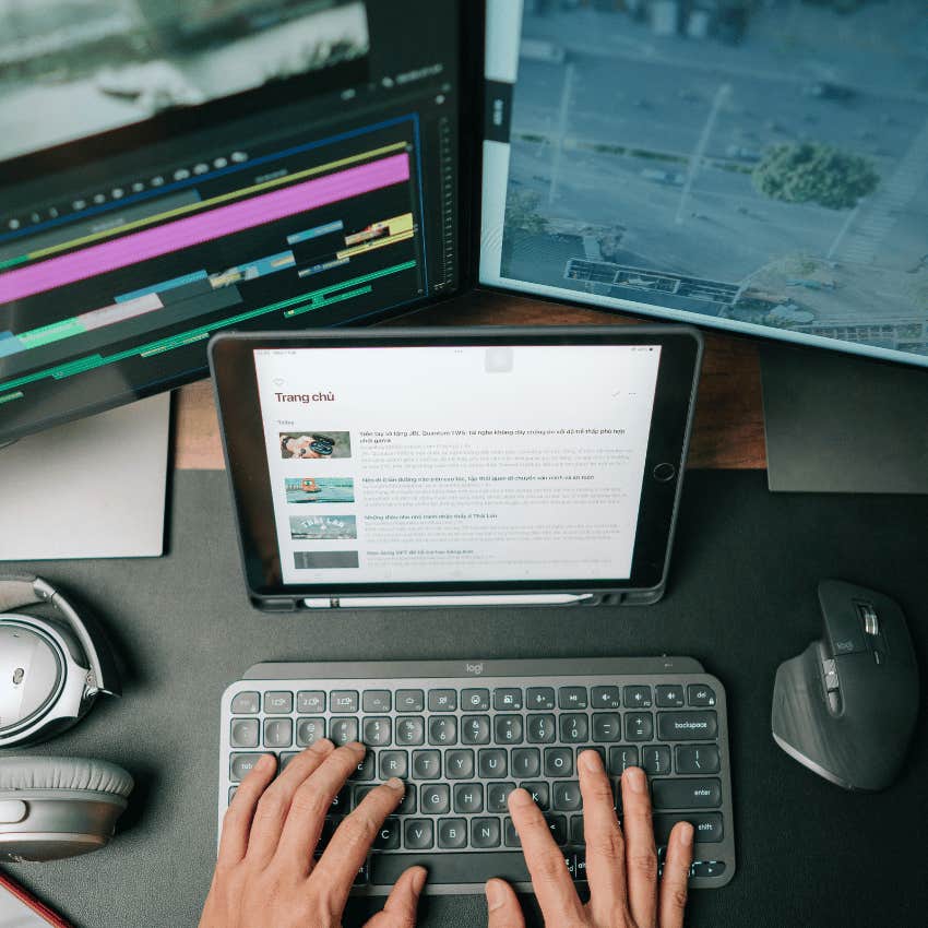 hands typing with three screens