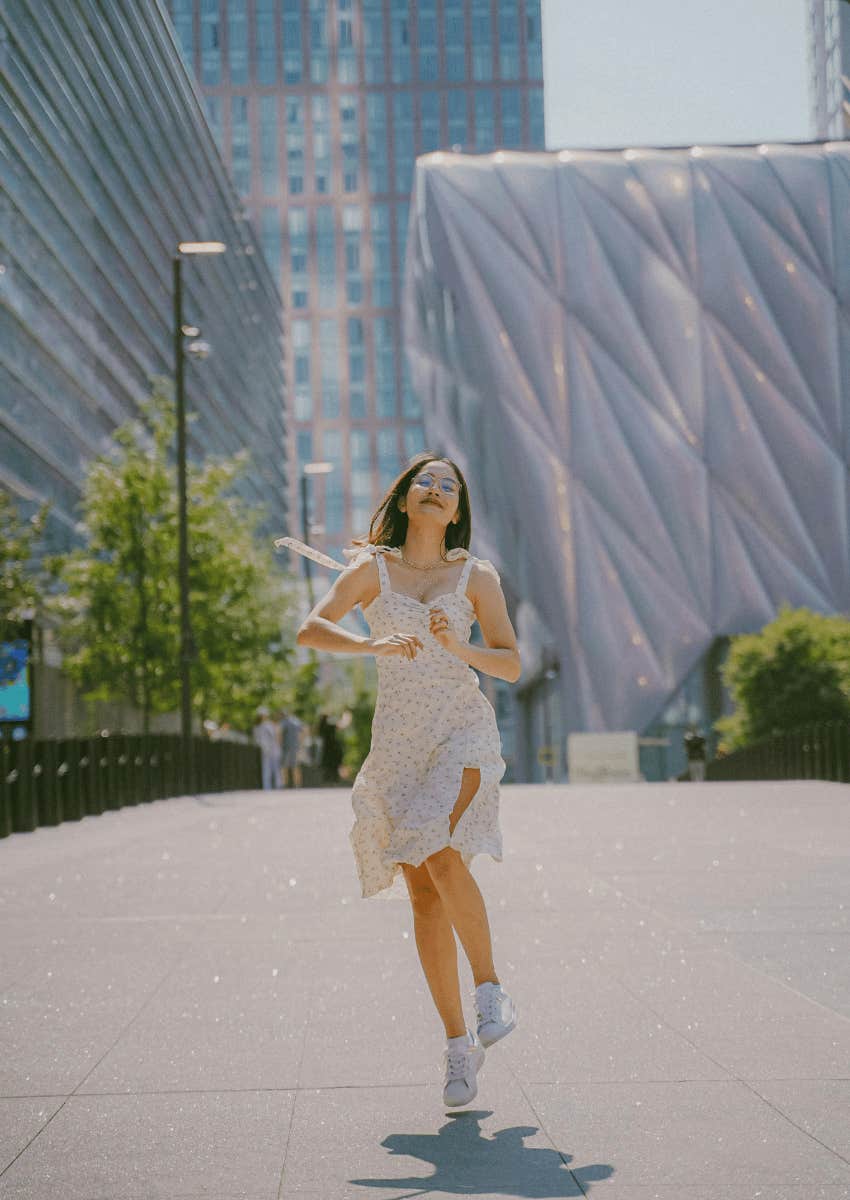 happy young woman skipping outdoors