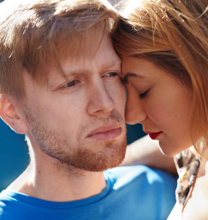 She leans her forhead on his cheek and he is expresionless