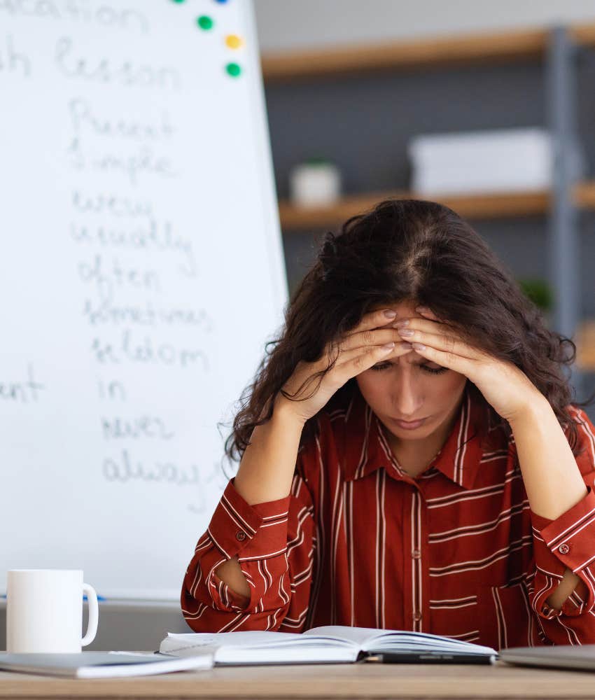 teacher feeling overwhelmed with head in her hands