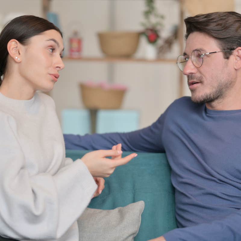 wife and husband having conversation at home on couch