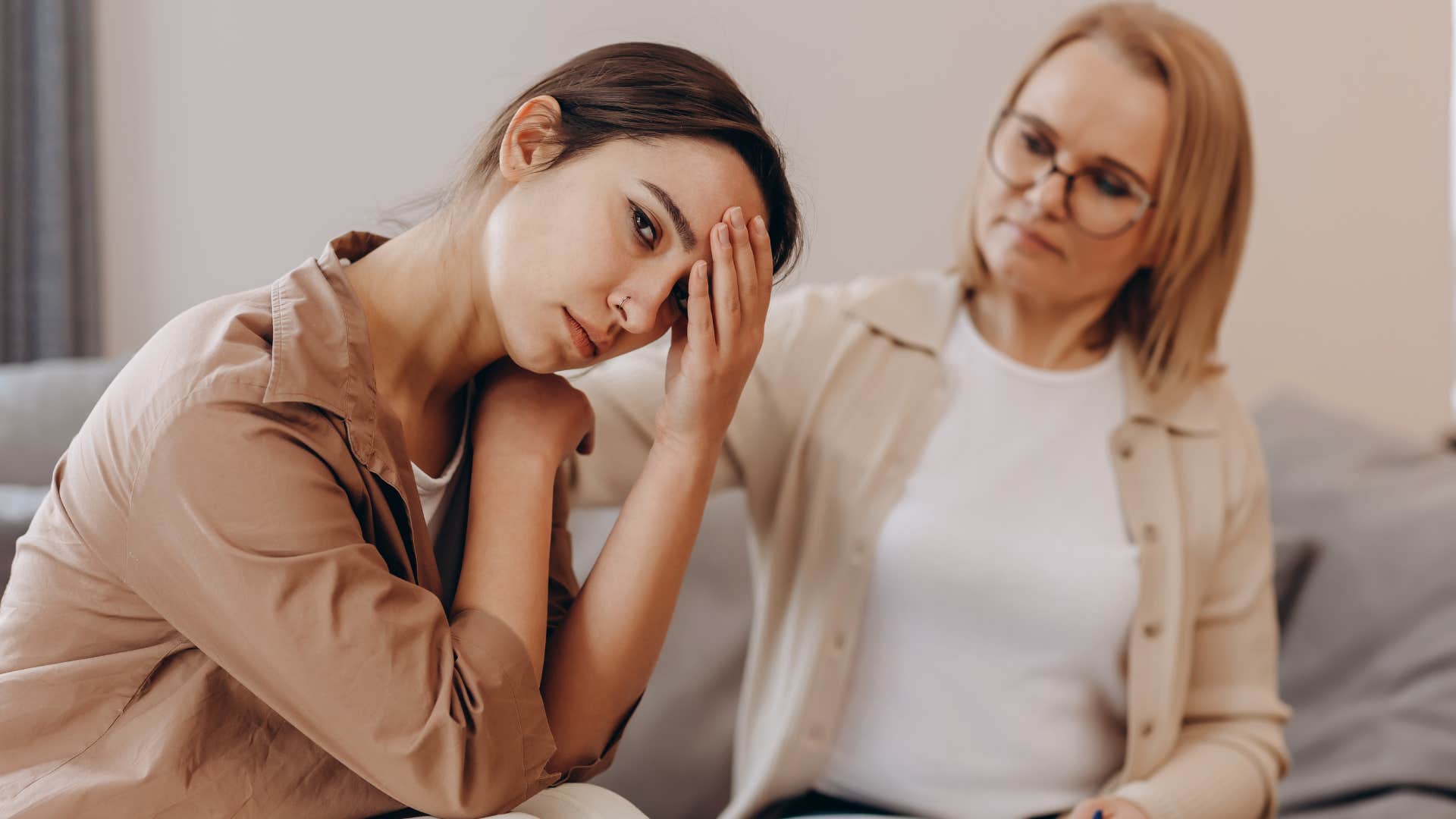 Mother comforting narcissistic adult child at home. 