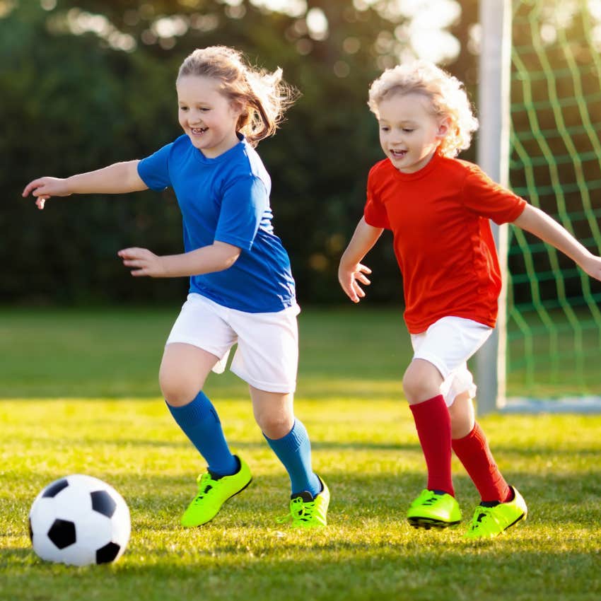 Kids playing during a soccer game together. 