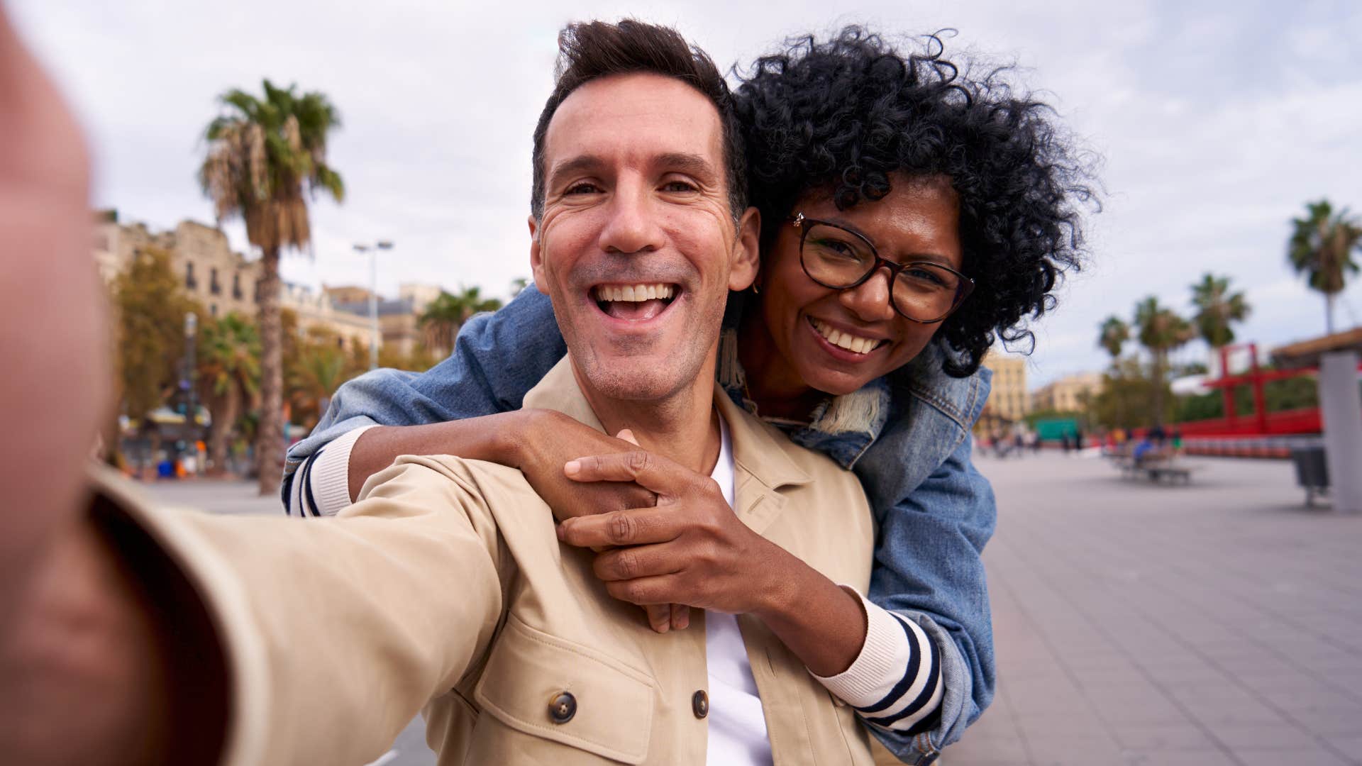 Man and woman hugging while taking a picture together.