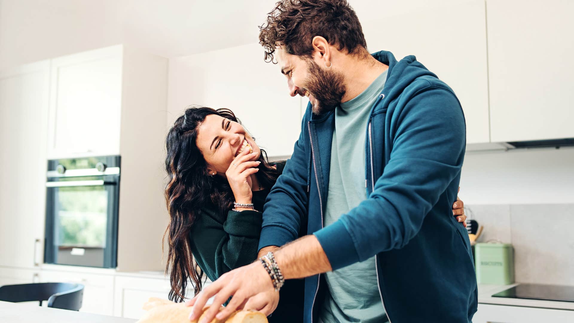 Couple smiling in their kitchen together.