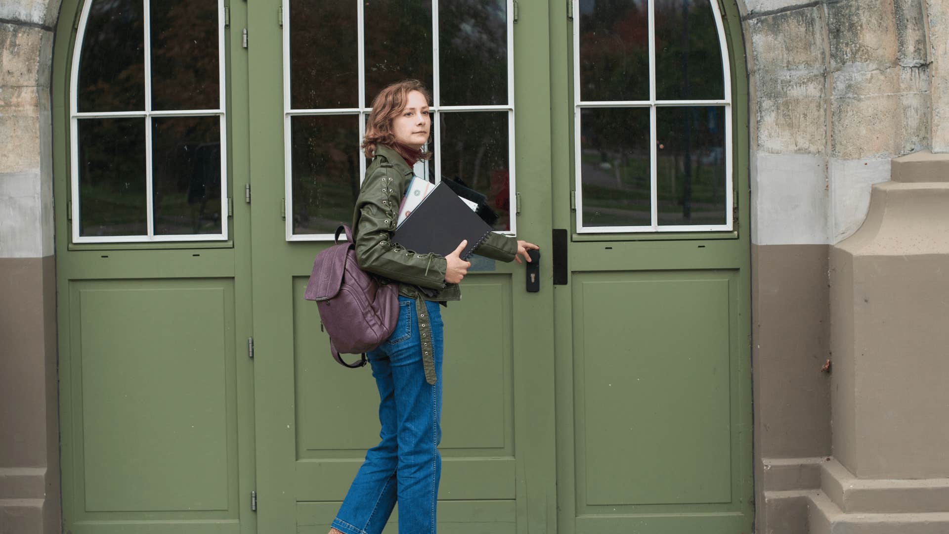 woman opening green door