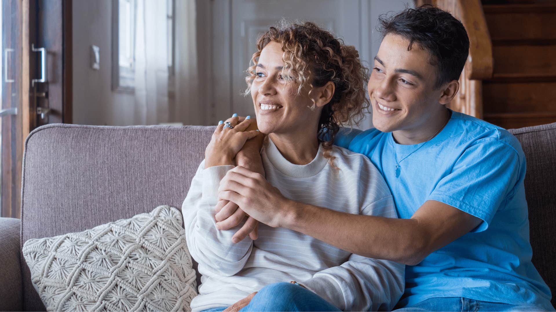 son hugging mom while they sit down