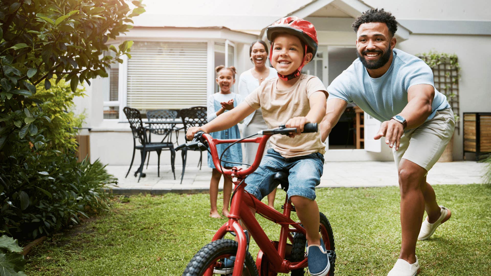 dad teaching son to ride a bike